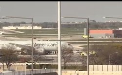Emergency services swarm American Airlines plane as it 'blows two tyres' in landing